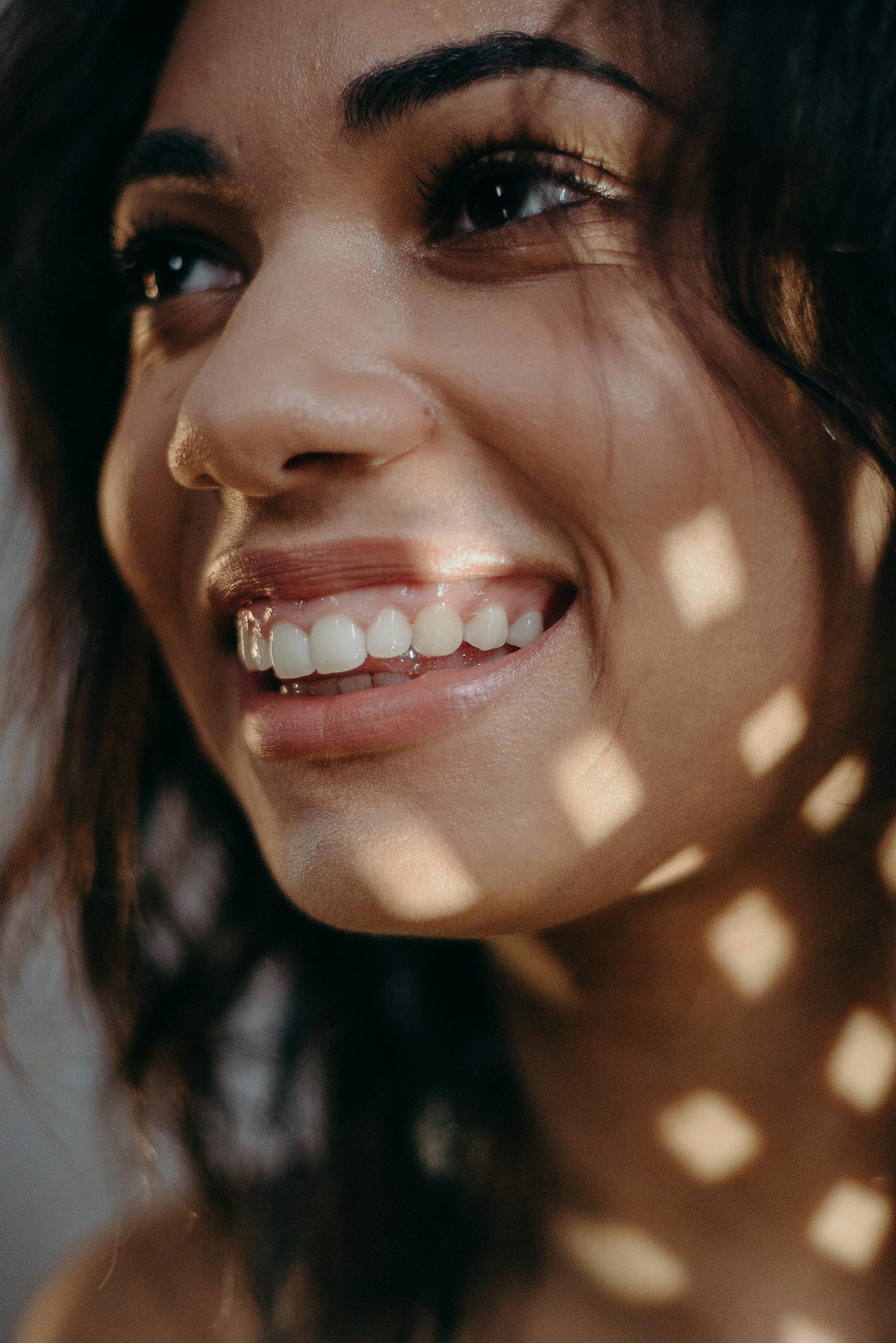 Close-up portrait of a smiling woman with natural lighting.